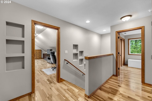 corridor with built in features and light hardwood / wood-style flooring