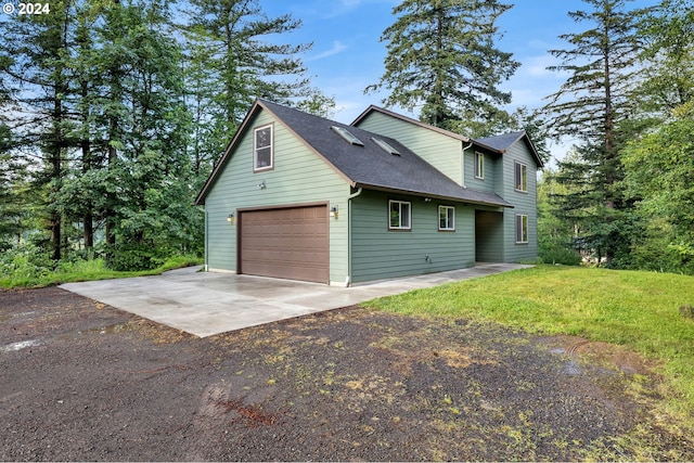 view of side of property with a garage and a lawn