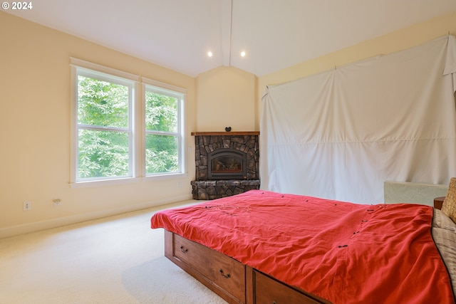 bedroom featuring a fireplace, light carpet, and vaulted ceiling