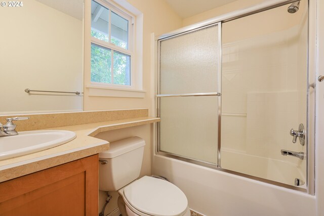 full bathroom with shower / bath combination with glass door, vanity, and toilet