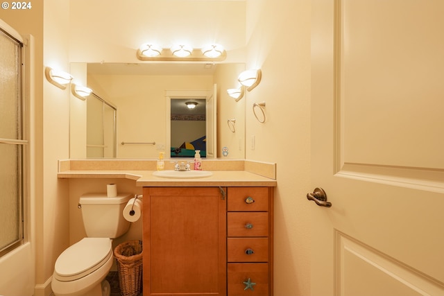 full bathroom featuring combined bath / shower with glass door, vanity, and toilet