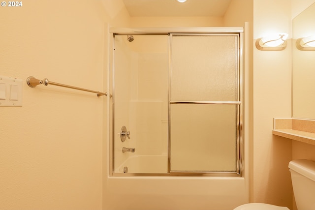 bathroom featuring shower / bath combination with glass door and toilet