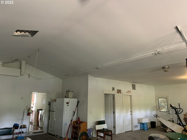 garage with washer / dryer, white fridge, and sink