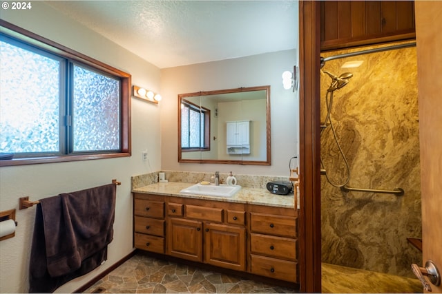 bathroom featuring plenty of natural light, vanity, and a shower