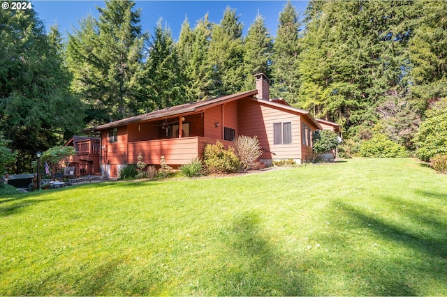 view of side of home with a lawn and a deck