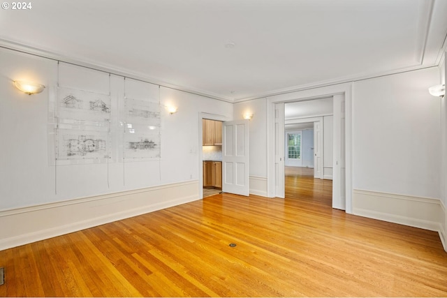 spare room featuring ornamental molding and light hardwood / wood-style flooring