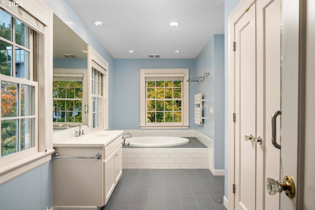 bathroom with vanity and a relaxing tiled tub