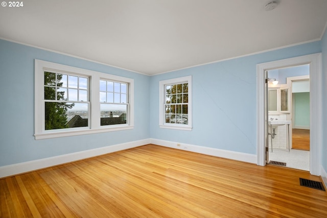 spare room featuring hardwood / wood-style flooring and crown molding