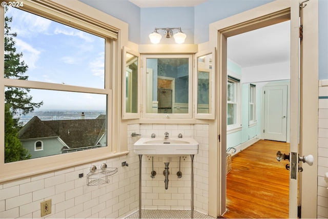 bathroom with sink, tile walls, and hardwood / wood-style floors