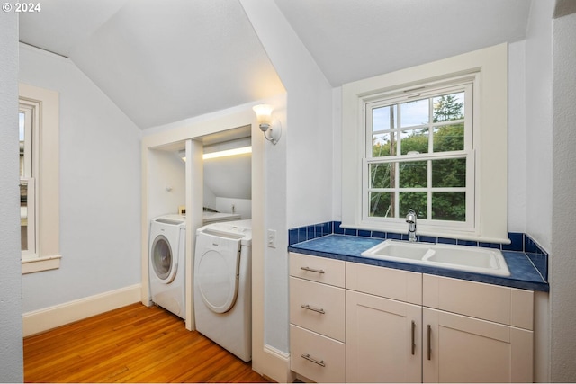 washroom featuring separate washer and dryer, sink, and light wood-type flooring