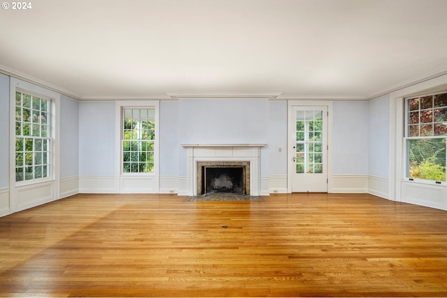 unfurnished living room featuring light hardwood / wood-style floors, a healthy amount of sunlight, and crown molding