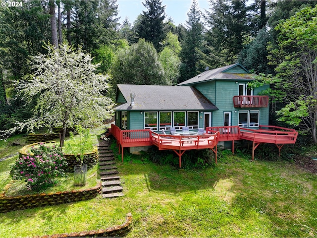 back of house featuring a wooden deck and a lawn