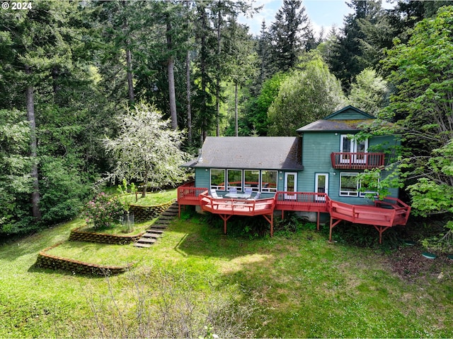 rear view of house with a deck and a lawn