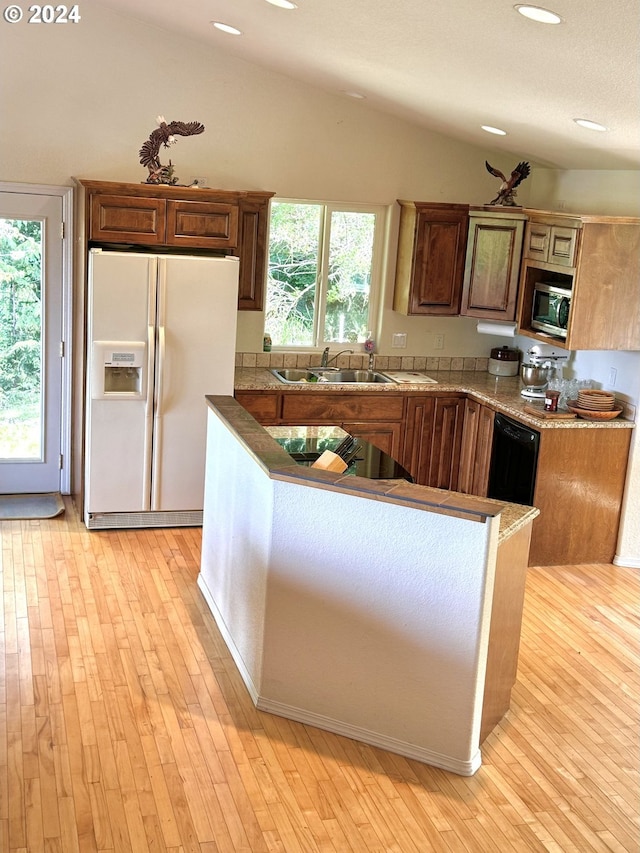 kitchen with lofted ceiling, sink, light hardwood / wood-style floors, and white fridge with ice dispenser