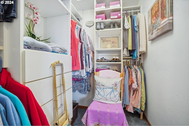 walk in closet with dark colored carpet