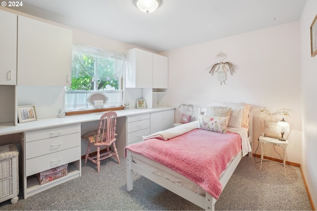 carpeted bedroom featuring built in desk