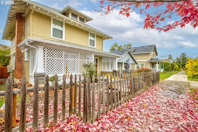 traditional style home with a fenced front yard and brick siding