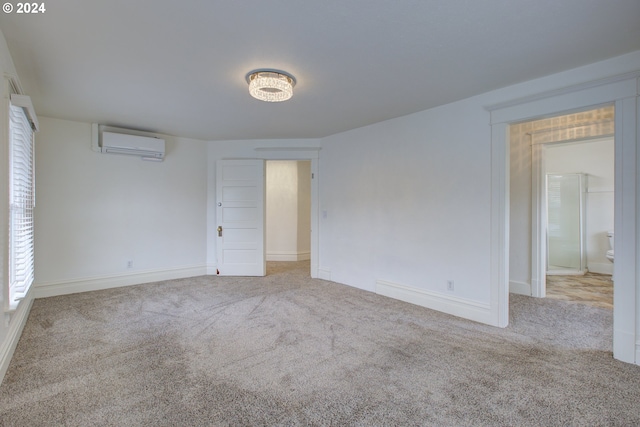 carpeted spare room with a wall mounted air conditioner and baseboards