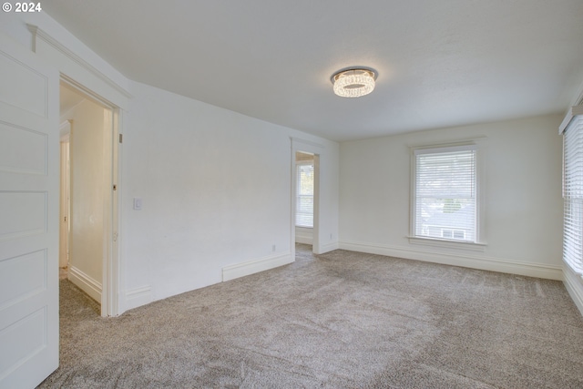 empty room featuring baseboards and carpet floors