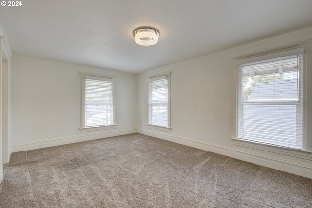 carpeted spare room featuring baseboards