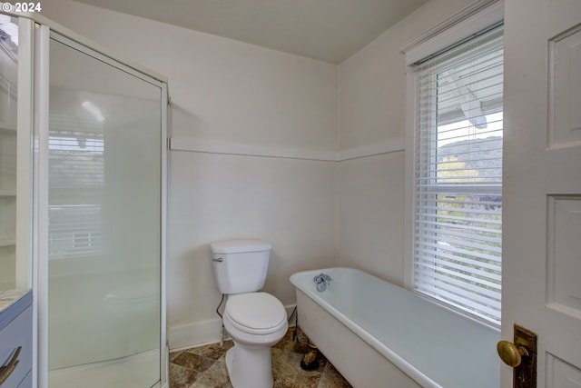 bathroom with a shower stall, stone finish flooring, toilet, a soaking tub, and vanity