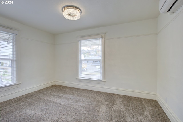 carpeted empty room featuring baseboards, a healthy amount of sunlight, and a wall mounted AC