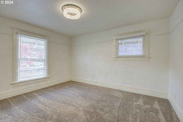 carpeted spare room with baseboards