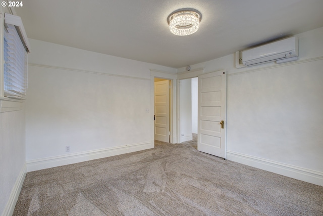 unfurnished bedroom with a wall unit AC, carpet, and baseboards