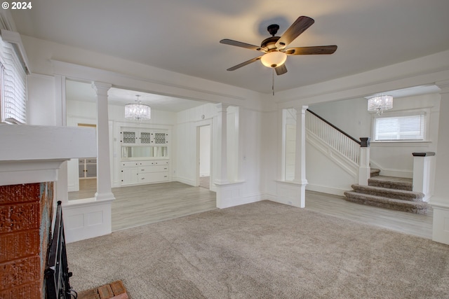 unfurnished living room featuring light colored carpet and ornate columns