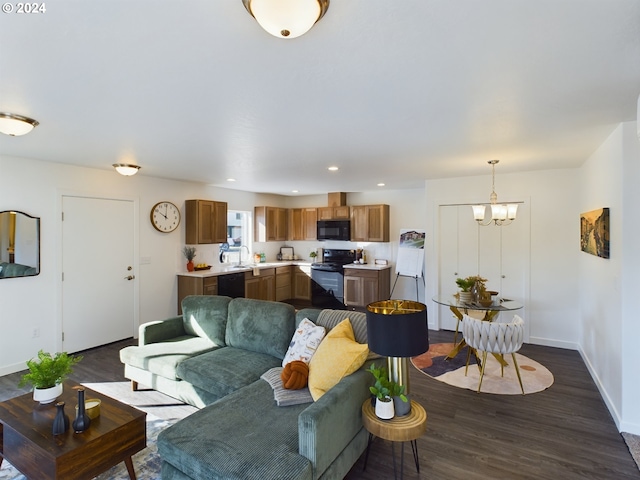 living room with sink, dark wood-type flooring, and a notable chandelier