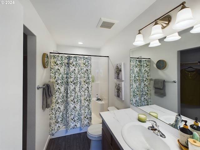 bathroom with hardwood / wood-style floors, vanity, curtained shower, and toilet