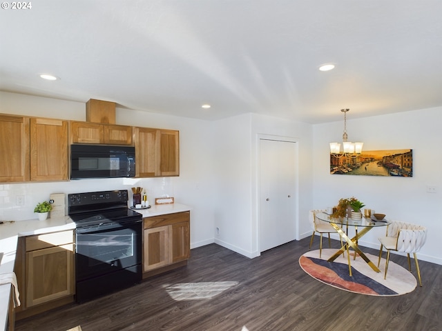 kitchen with dark wood-type flooring, black appliances, decorative light fixtures, and an inviting chandelier