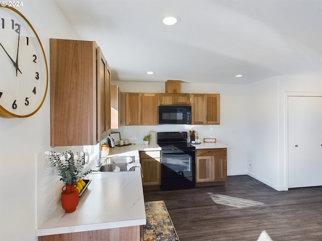 kitchen featuring black appliances, dark hardwood / wood-style floors, and sink