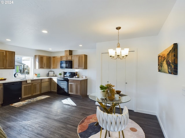 kitchen with black appliances, decorative light fixtures, dark hardwood / wood-style floors, and sink