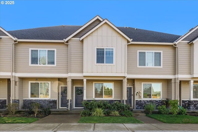 multi unit property featuring a shingled roof and board and batten siding