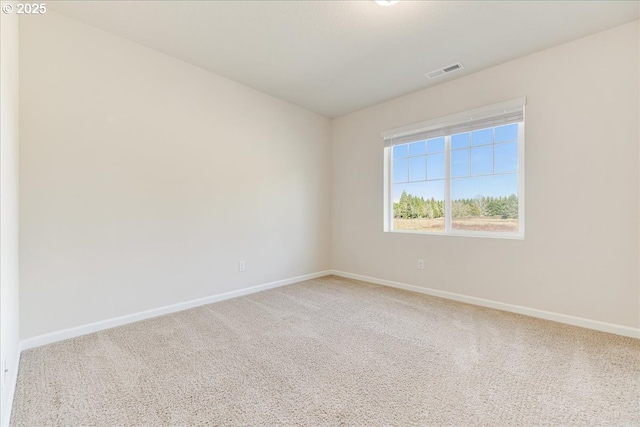 empty room with baseboards, visible vents, and carpet flooring