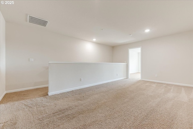 spare room featuring light carpet, visible vents, and recessed lighting