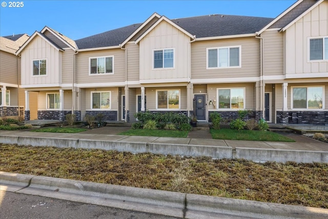 townhome / multi-family property with a shingled roof and board and batten siding