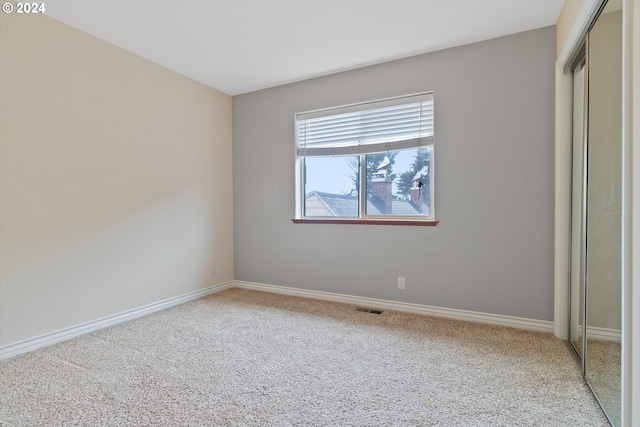 unfurnished bedroom with visible vents, carpet, a closet, and baseboards