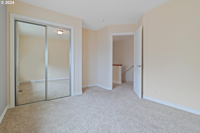 unfurnished bedroom with a closet, baseboards, and carpet