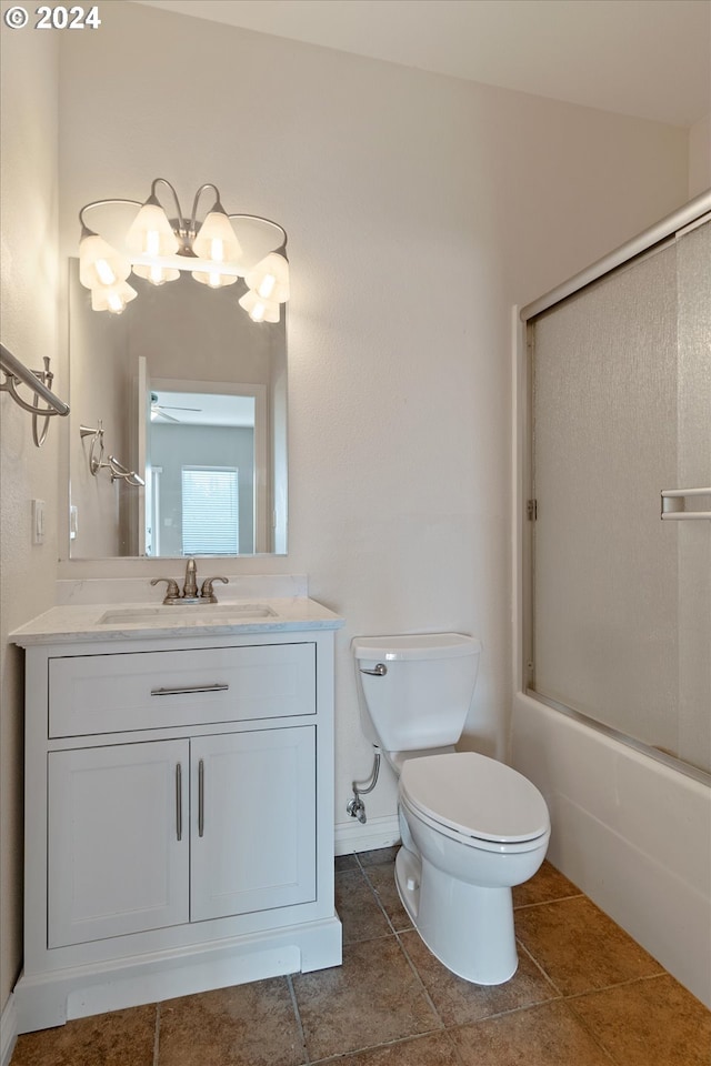 full bath with tile patterned floors, combined bath / shower with glass door, toilet, and vanity