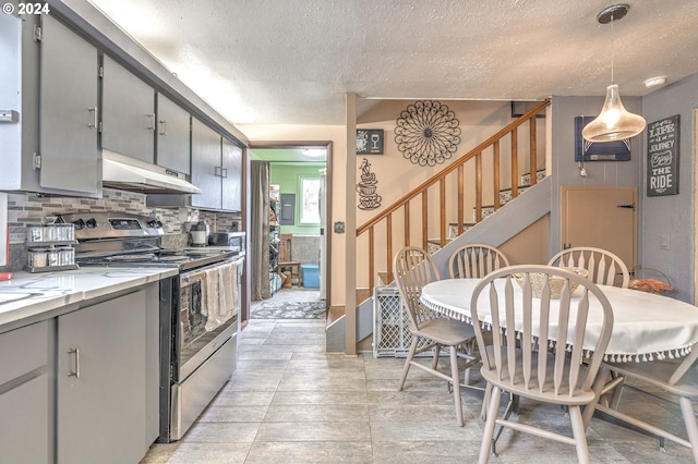 kitchen with tasteful backsplash, gray cabinetry, a textured ceiling, hanging light fixtures, and stainless steel range with electric cooktop