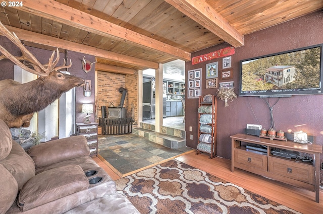 living room featuring hardwood / wood-style floors, a wood stove, beamed ceiling, and wooden ceiling