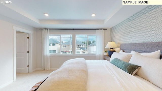 bedroom featuring a tray ceiling and carpet floors