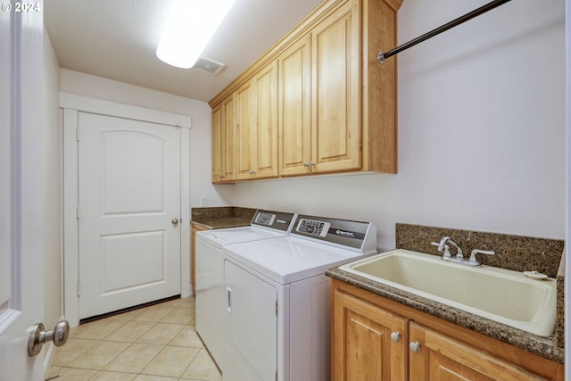 washroom featuring washing machine and clothes dryer, cabinets, light tile patterned floors, and sink