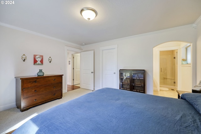 carpeted bedroom with ensuite bath and ornamental molding