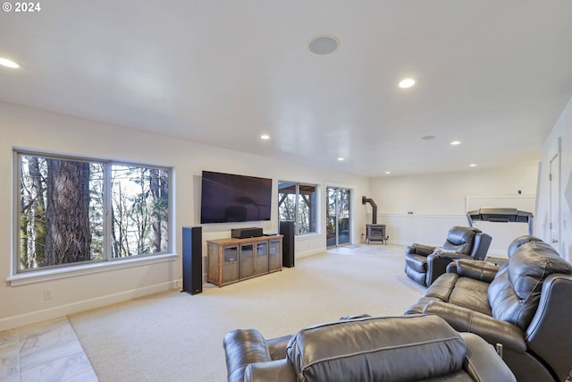 living room featuring light colored carpet and a wood stove