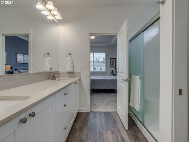 bathroom featuring wood-type flooring, vanity, and a shower with shower door