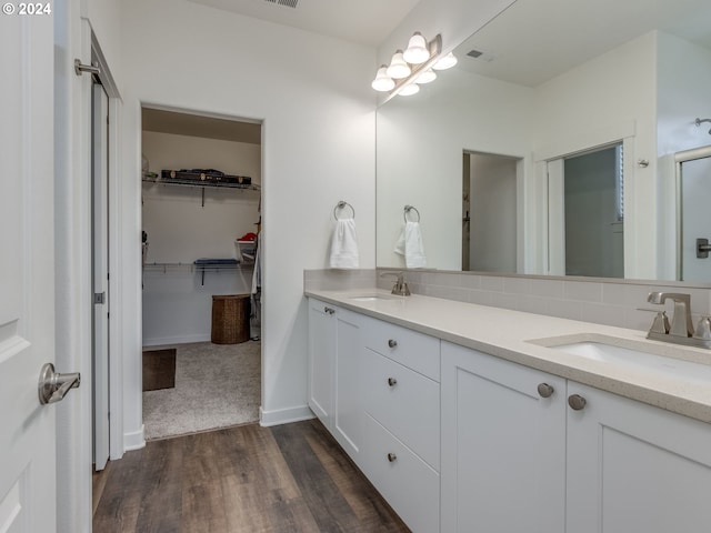 bathroom with hardwood / wood-style floors, vanity, and backsplash