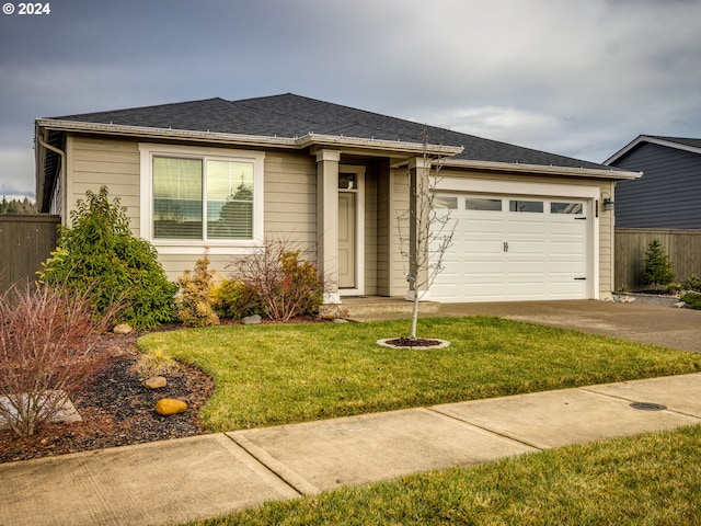 view of front of property with a front yard and a garage